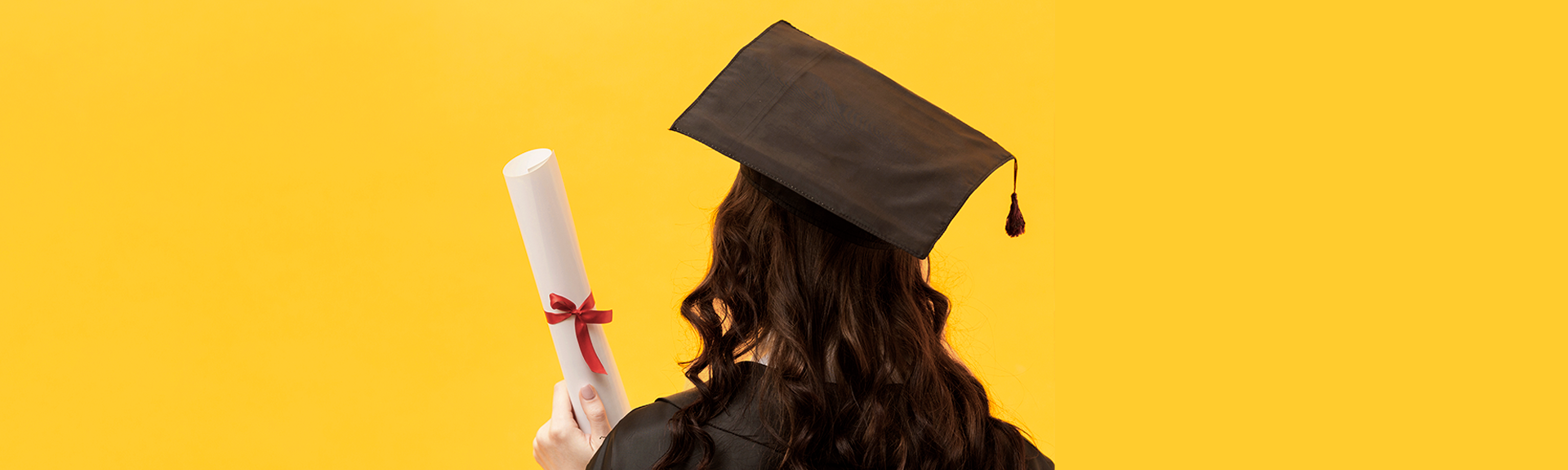 header étudiante diplômée d'école de commerce en toge et chapeau de dos avec son diplôme